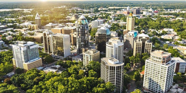 Charlotte NC skyline with modern buildings and greenery.