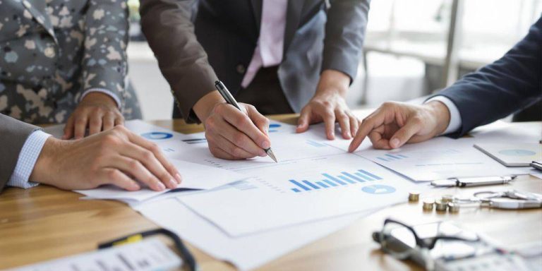 Diverse professionals collaborating on accounting tasks.