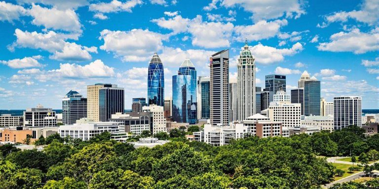 Charlotte skyline with greenery, highlighting investment opportunities.