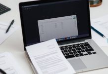 Workspace with laptop, financial documents, and a calculator.