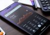 Smartphone with Google Finance app on a stylish desk.