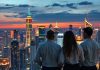 Global city skyline at dusk with diverse individuals discussing.