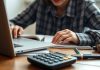 Student studying financial management notes and tools on desk.