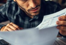 Person analyzing finance documents with calculators and notebooks.