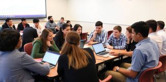 Students engaged in a stock market game in class.