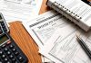 Bonds and financial documents on a wooden desk.