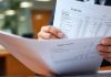 Business professional reviewing financial documents in an office.