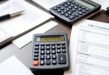 Calculator, notepad, and financial documents on a desk.