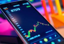 Smartphone showing stock data in an office setting.