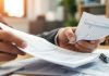 Business professional reviewing financial documents in an office.