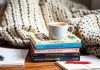 Colorful investing books and coffee in a cozy setting.
