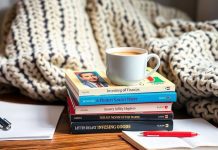 Colorful investing books and coffee in a cozy setting.