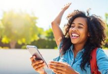 Person using smartphone outdoors, representing financial empowerment.
