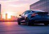 Tesla car in a modern city at sunset.