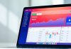 Modern laptop showcasing investment tracking features on screen.