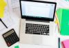 Workspace with laptop and financial documents for analysis.