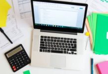 Workspace with laptop and financial documents for analysis.