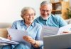 Happy couple discussing retirement plans at home.