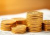 Golden coins stacked on a financial statement.
