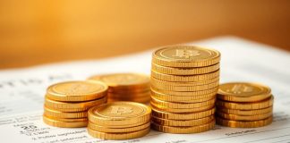 Golden coins stacked on a financial statement.