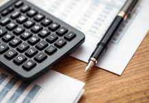 Calculator and documents on a desk for investment analysis.