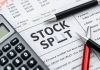 Calculator and pen on a financial newspaper about stocks.