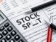Calculator and pen on a financial newspaper about stocks.