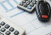 Calculator with vehicle keys on a budget planning surface.