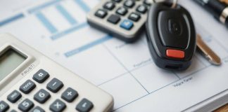 Calculator with vehicle keys on a budget planning surface.
