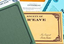 Three stock certificates on a wooden desk.
