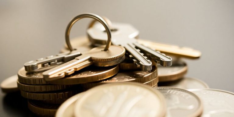 Keys on house-shaped coin pile.