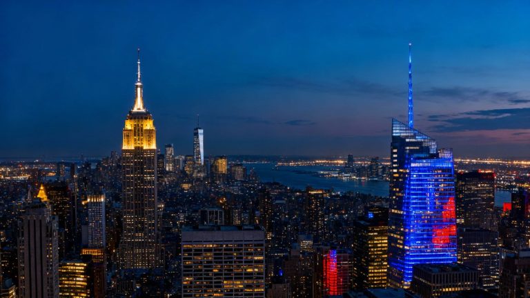 New York City skyline at dusk with illuminated skyscrapers.