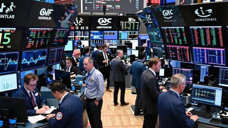 Stock market trading floor with active traders and digital displays.