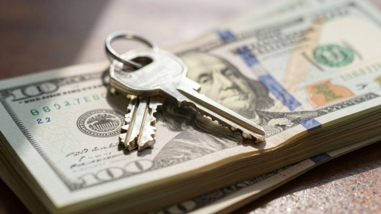 House key on money, mortgage interest rates