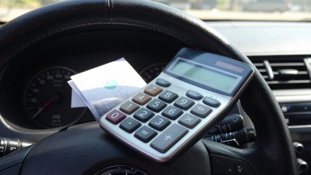Car dashboard with calculator on steering wheel.
