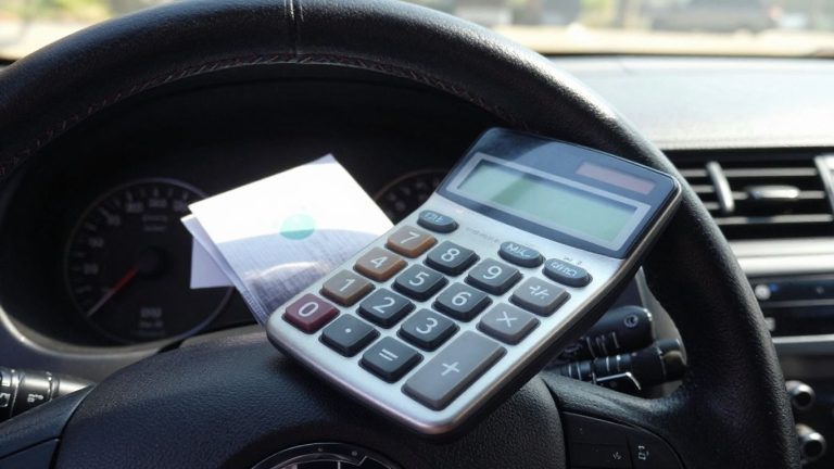 Car dashboard with calculator on steering wheel.