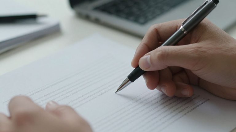 Hand filling out SBA disaster loan application form.